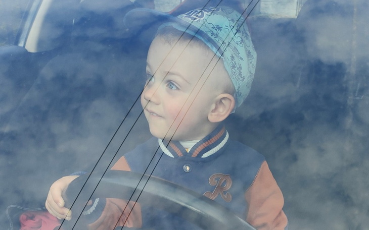 Mały chłopiec za kierownicą samochodu.