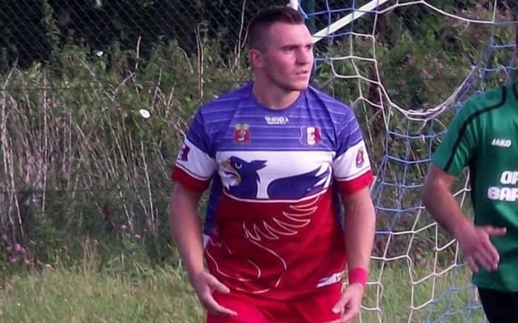 Mężczyzna w piłkarskim stroju na boisku.