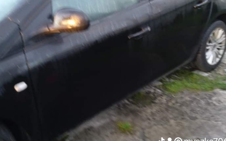 Czarny samochód na mokrej nawierzchni.