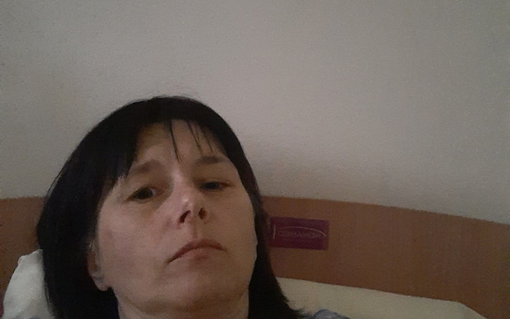 Kobieta leżąca w łóżku, wygląda na zamyśloną.