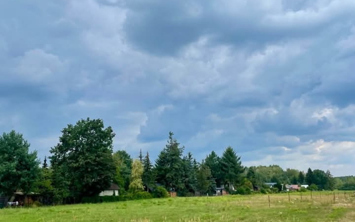 Widok na chmurne niebo nad zielonym krajobrazem.