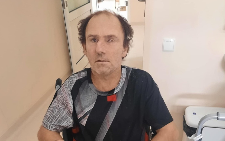 Mężczyzna na wózku inwalidzkim, z zamyślonym wyrazem twarzy.