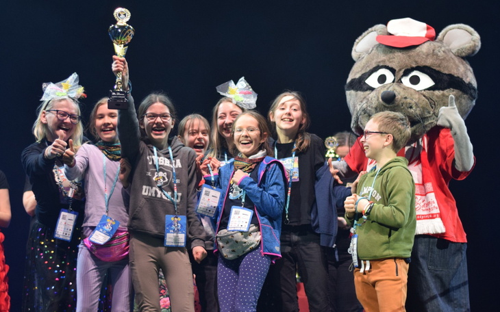 Grupa dzieci z trofeum, radosne chwile po zwycięstwie.