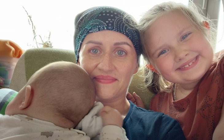 Mama z dziećmi, uśmiechnięta w domowej atmosferze.