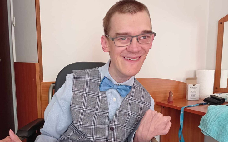 Mężczyzna w eleganckim stroju z uśmiechem na twarzy.