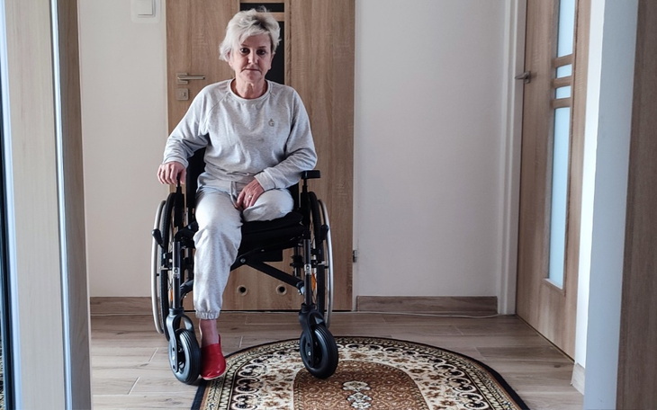 Kobieta na wózku inwalidzkim, w jasnym pomieszczeniu.