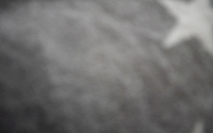 Rozmyty obraz z gwiazdą, w odcieniach szarości.