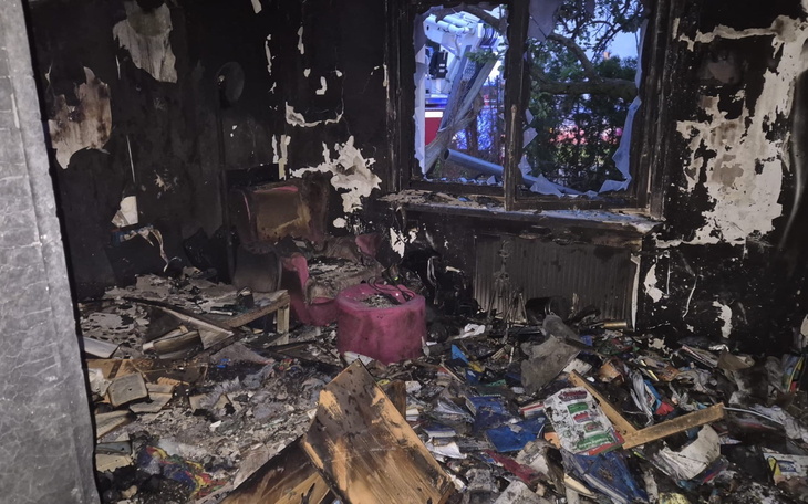 Zniszczony pokój po pożarze, z bałaganem i uszkodzeniami.