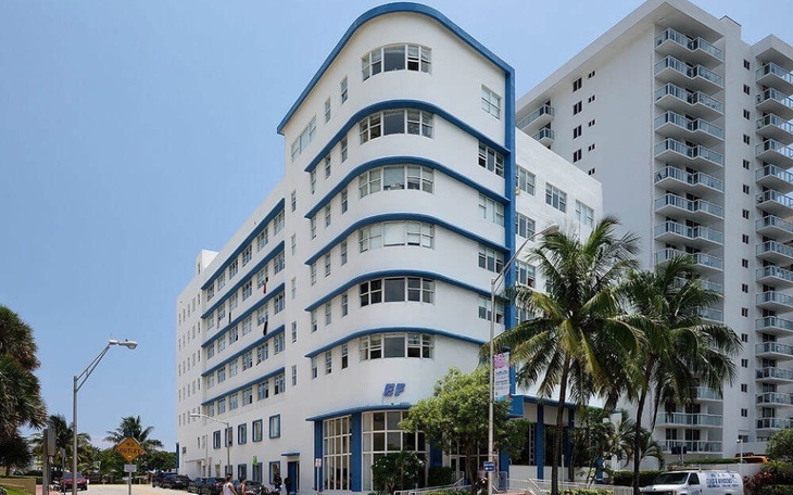 Nowoczesny budynek w Miami, z palmami w tle.