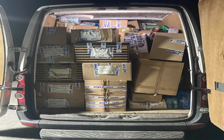 Wnętrze furgonetki wypełnionej paczkami.