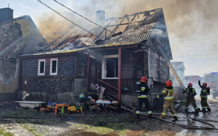 Pożar w drewnianym domu, strażacy w akcji.