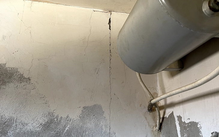 Zniszczona ściana w pomieszczeniu, z pęknięciami i wilgocią.