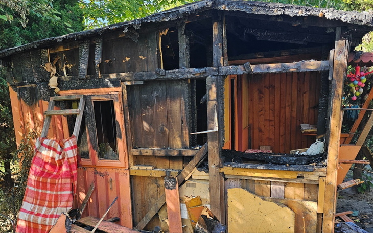 Zniszczona chatka po pożarze, widoczne uszkodzenia.