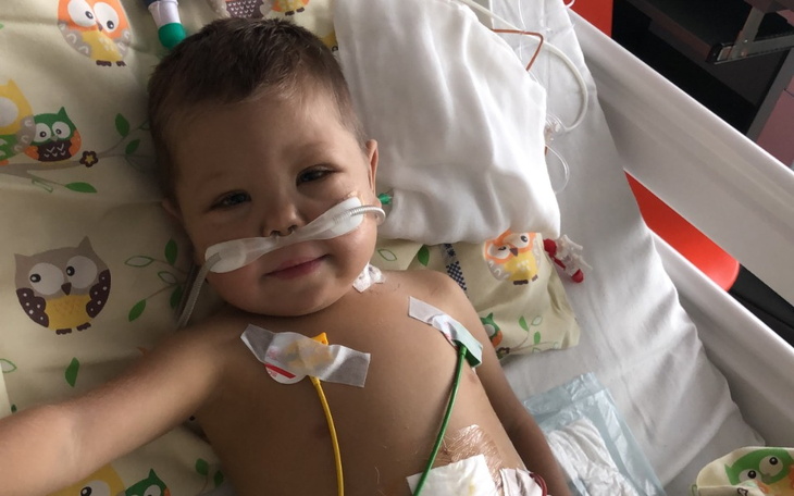 Chłopiec w szpitalu, uśmiechający się do kamery.