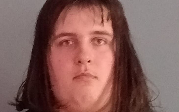 Portret młodej osoby z długimi włosami, patrzącej w obiektyw.