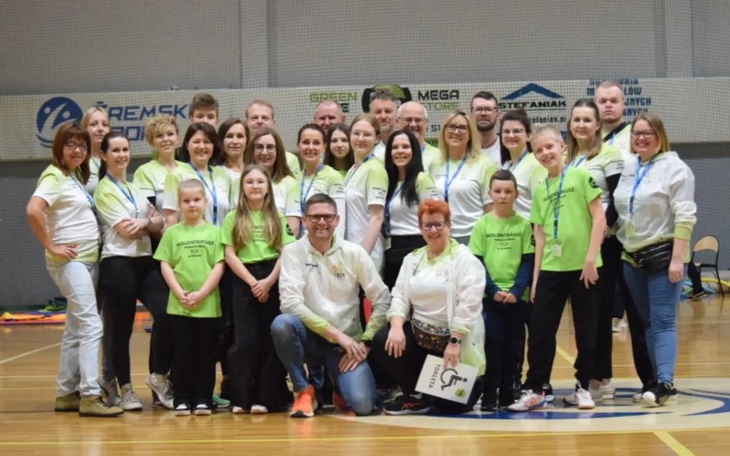 Grupa ludzi w strojach sportowych na wydarzeniu.