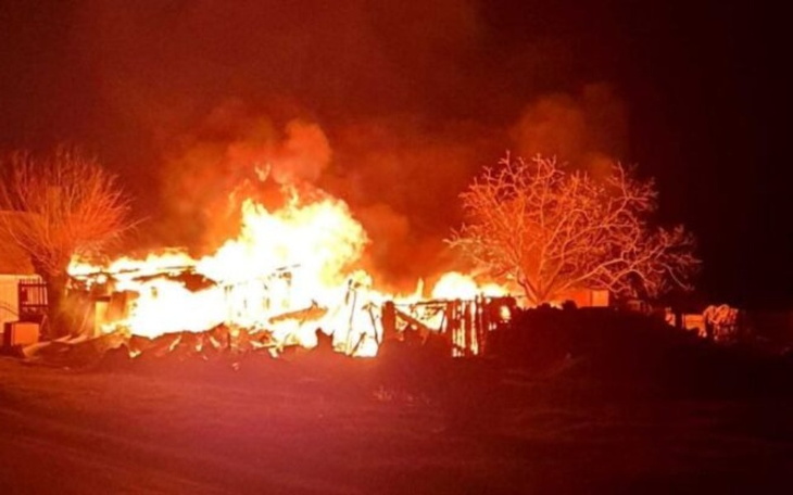 Płonący budynek w nocy, z intensywnym ogniem.