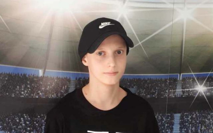 Chłopiec w czapce Nike na tle stadionu.