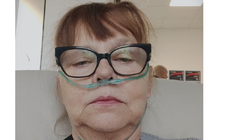 Kobieta z tlenem, wyrażająca zmęczenie i troskę.