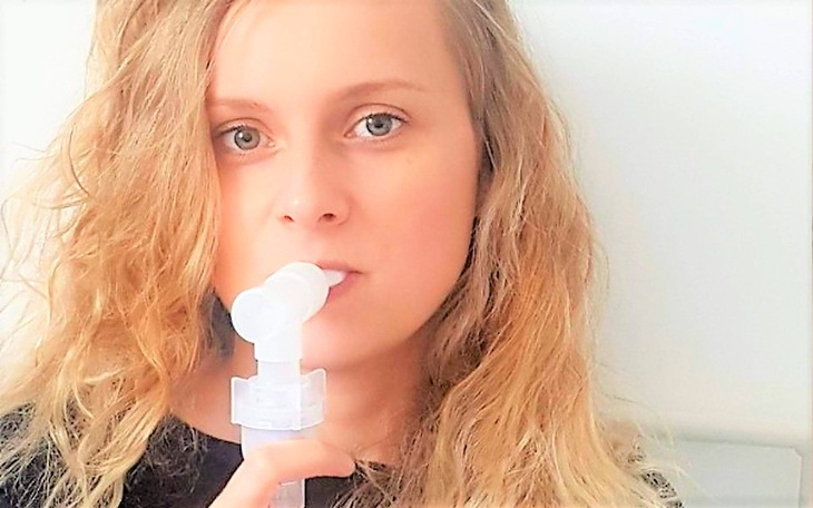 Młoda kobieta używa inhalatora, dbając o zdrowie.