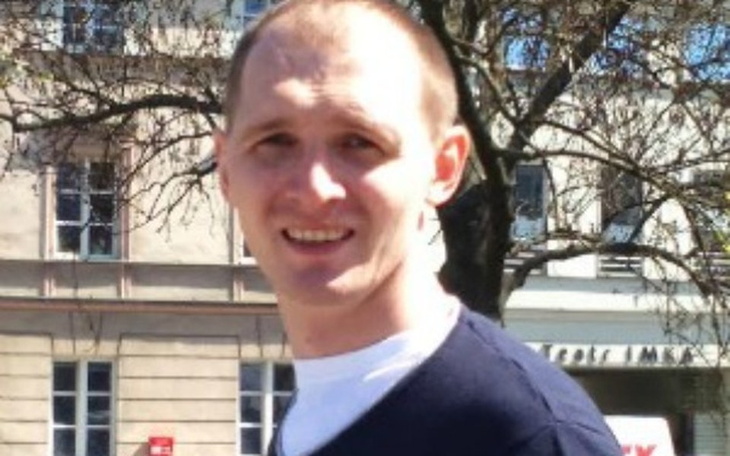 Mężczyzna uśmiechający się na ulicy.