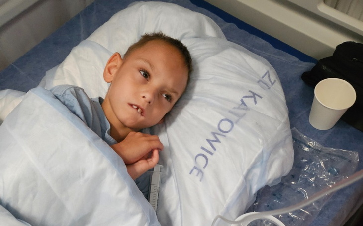 Dziecko leżące w szpitalnym łóżku, owinięte w koc.