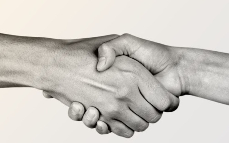 Dwie ręce w uścisku, symbolizujące współpracę i zaufanie.