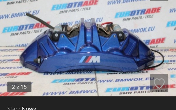 Niebieski zacisk hamulcowy na tle reklamy części samochodowych.