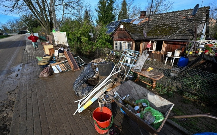 Zniszczony dom z porzuconymi przedmiotami po powodzi.