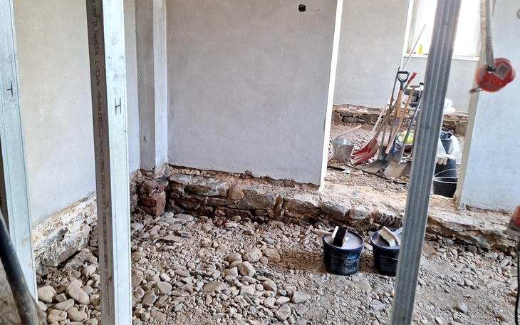 Wnętrze budynku w trakcie remontu, z narzędziami i materiałami.