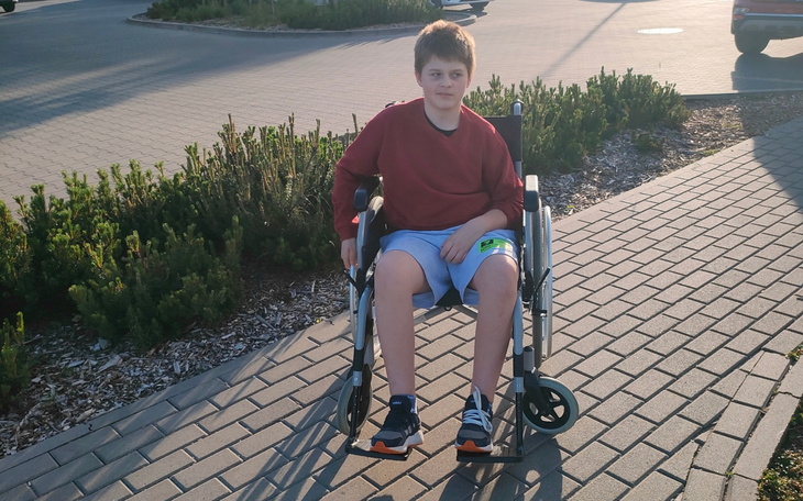 Chłopiec na wózku inwalidzkim, spędzający czas na świeżym powietrzu.