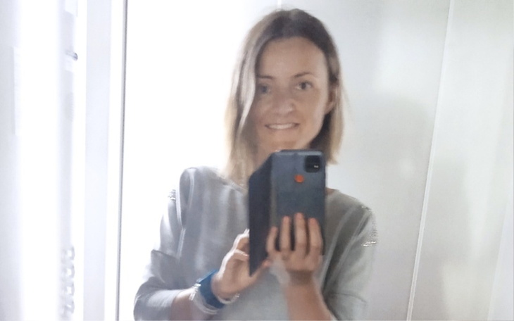 Osoba robiąca selfie w lustrze, uśmiechnięta.