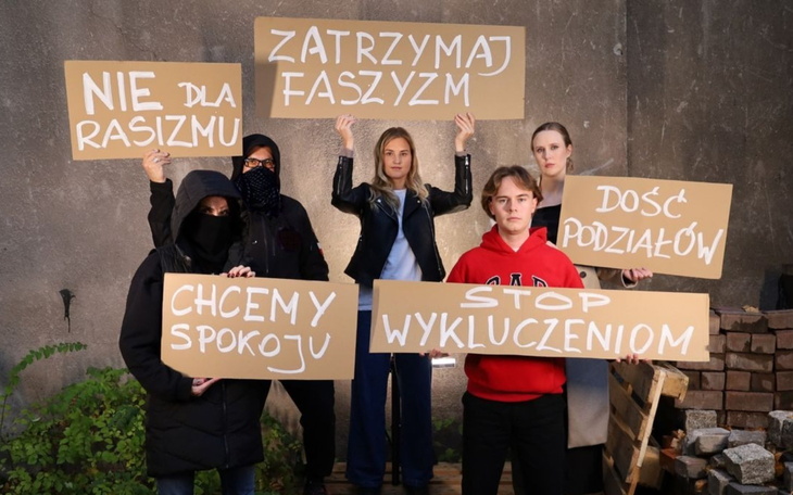 Grupa ludzi z transparentami, protestujących przeciwko dyskryminacji.