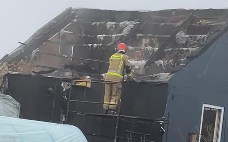 Strażak pracujący przy zgliszczach spalonego budynku.