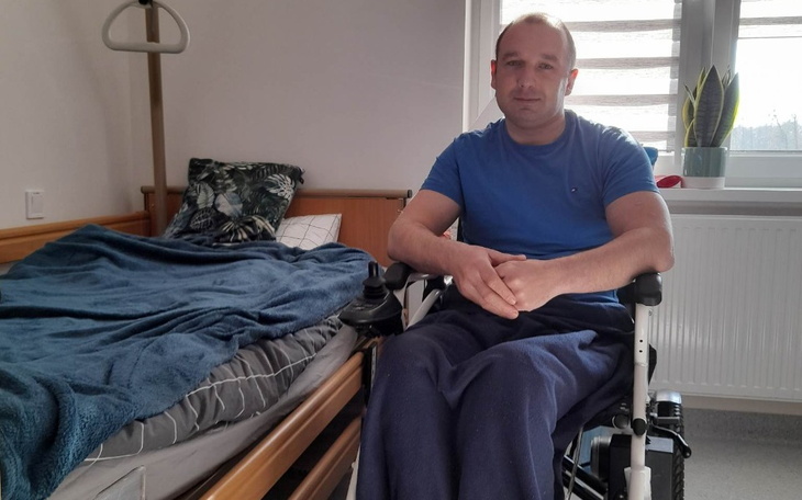 Mężczyzna na wózku inwalidzkim w pokoju.