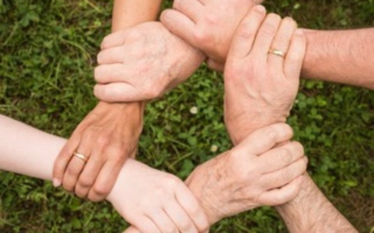 Ręce różnych osób splątane w symbolu jedności.