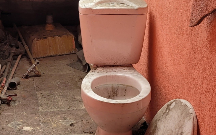 Stara toaleta w nieuporządkowanym pomieszczeniu.