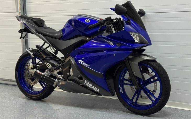 Niebieski motocykl sportowy zaparkowany w garażu.
