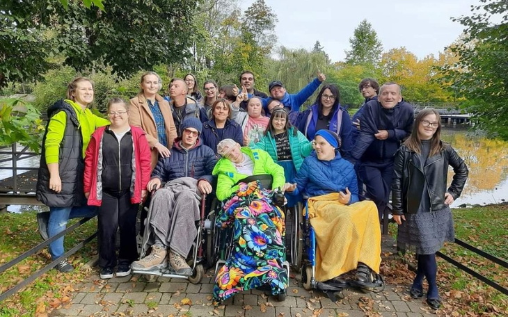 Grupa ludzi w parku, uśmiechniętych i radosnych.