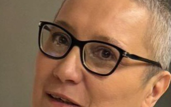 Kobieta w okularach, uśmiechająca się do kamery.