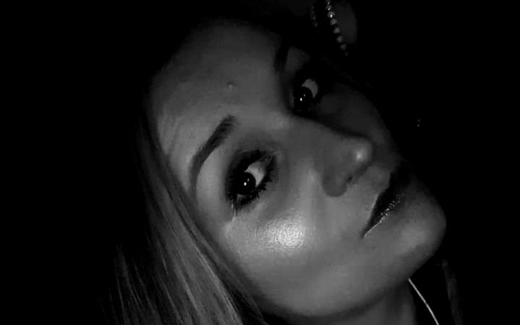 Czarno-białe zdjęcie kobiety z wyrazem twarzy pełnym tajemniczości.