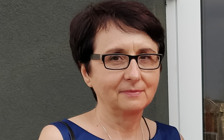 Kobieta w okularach, uśmiechająca się do kamery.