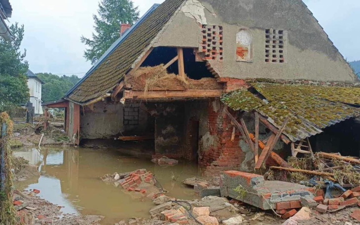 Zniszczony dom po powodzi, z widocznymi uszkodzeniami.