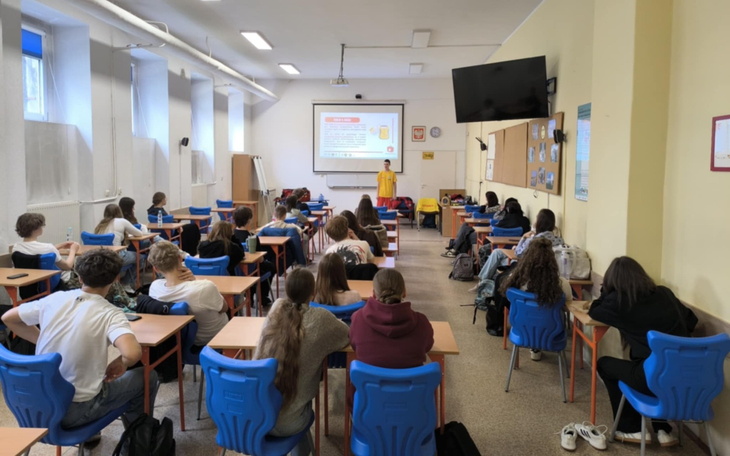 Uczniowie w klasie podczas wykładu, skupieni na nauczycielu.