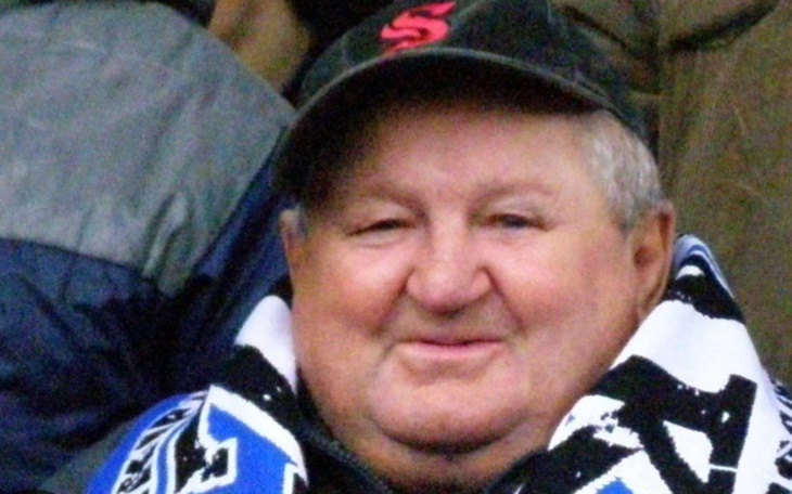 Uśmiechnięty mężczyzna w czapce i szaliku.