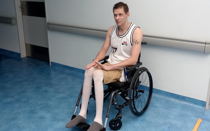 Mężczyzna w wózku inwalidzkim, ubrany w sportowy strój.