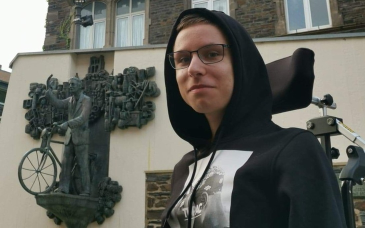 Młody mężczyzna przy pomniku, pozujący do zdjęcia.