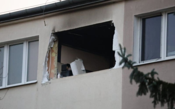 Zniszczona ściana budynku z dużym otworem, przez który widać wnętrze.