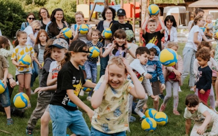 Dzieci bawiące się na placu zabaw z piłkami.