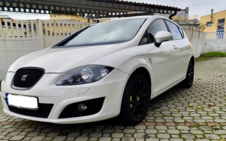 Biały samochód zaparkowany na kostce brukowej.